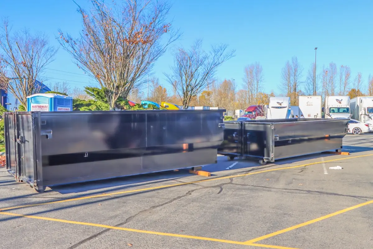 Professional dumpster rental service with roll-off container on residential driveway in Bemiss